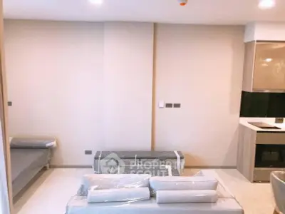 Modern unfurnished living room with neutral tones and sleek kitchen area