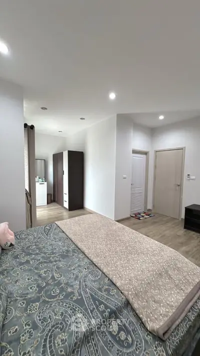 Spacious modern bedroom with stylish decor and ample natural light