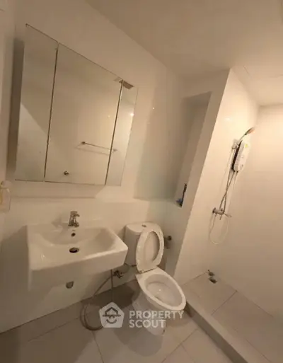 Modern bathroom with sleek fixtures and a minimalist design, featuring a shower and toilet.