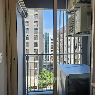 Compact balcony with city view and air conditioning unit in modern apartment.