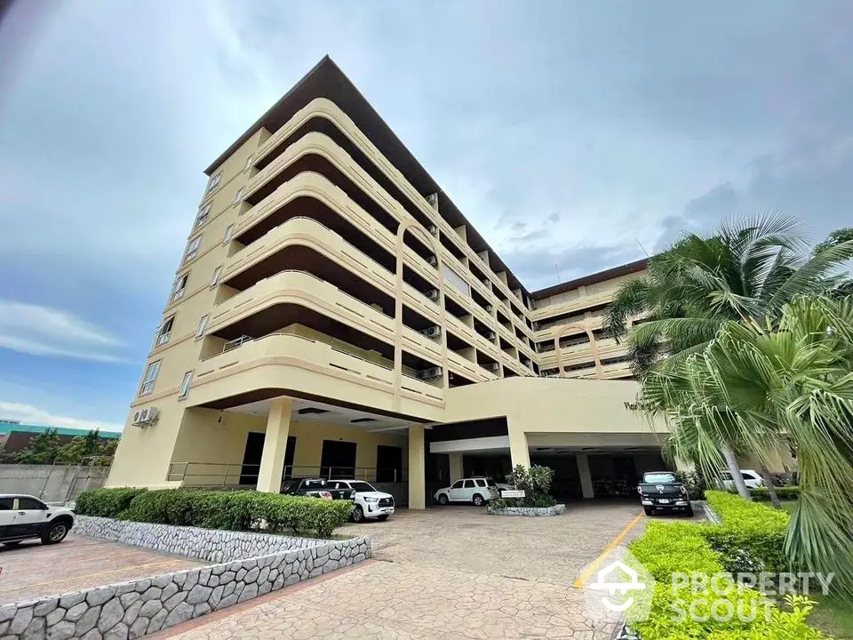 Modern multi-story residential building with spacious balconies and lush landscaping.