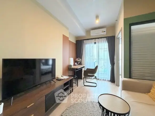 Modern living room with stylish furniture and natural light, featuring a cozy seating area and entertainment setup.