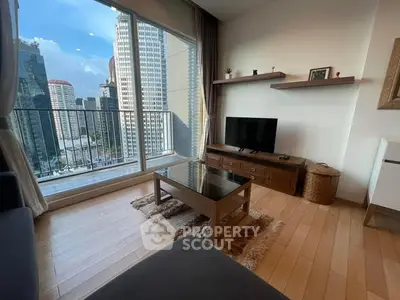 Modern living room with city view, featuring wooden floors, sleek furniture, and large windows.