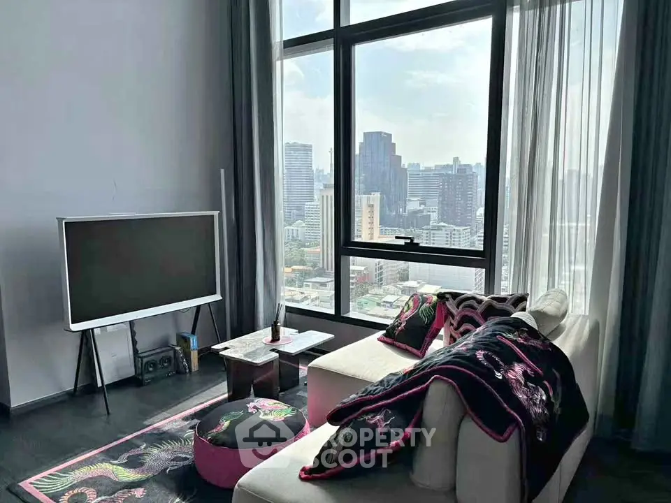 Modern living room with city view, stylish decor, and large windows in a high-rise apartment.