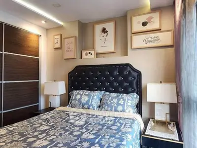 Elegant bedroom with stylish decor and floral bedding, featuring a tufted headboard and modern lighting.