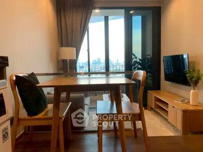Modern living room with city view, featuring stylish furniture and large windows for natural light.