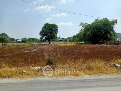 Expansive vacant land with potential for development, surrounded by greenery and open skies.