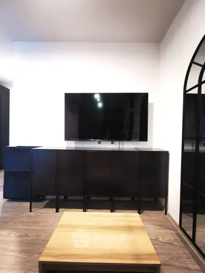 Modern living room with sleek black TV stand and mounted flat-screen TV.
