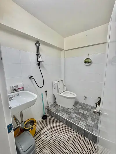 Modern bathroom with tiled floor and shower in a compact layout