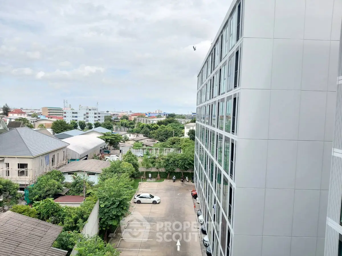 Modern apartment building with spacious parking and scenic city view.