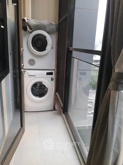 Modern balcony with washer and dryer overlooking city view, ideal for urban living.
