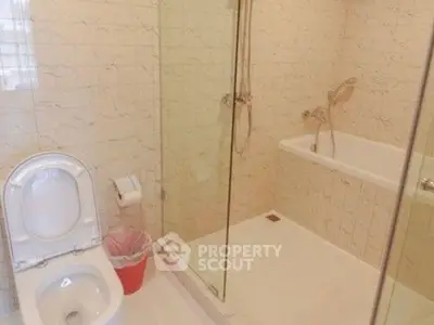 Modern bathroom with shower and bathtub in elegant tile setting.