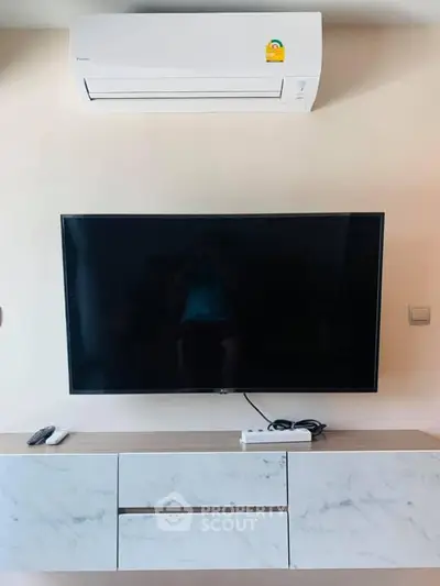 Modern living room with wall-mounted TV and air conditioning unit