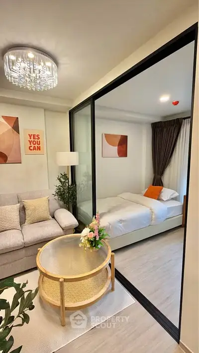 Modern studio apartment with glass partition, cozy living area, and stylish decor.