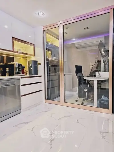 Modern kitchen with sleek appliances and adjacent glass-enclosed study area.