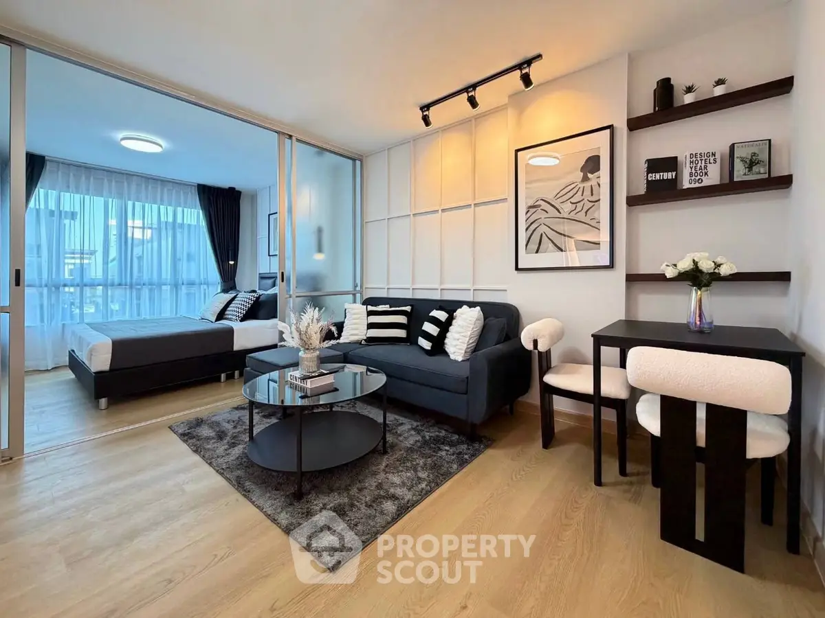 Modern open-plan living room with stylish decor and cozy bedroom area