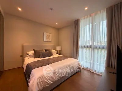 Luxurious bedroom with elegant decor and large window offering natural light.