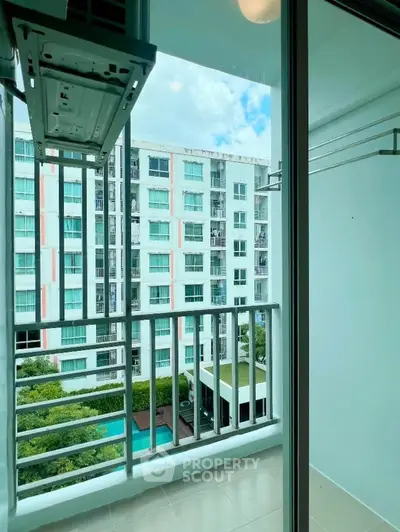 Modern apartment balcony with pool view in urban setting