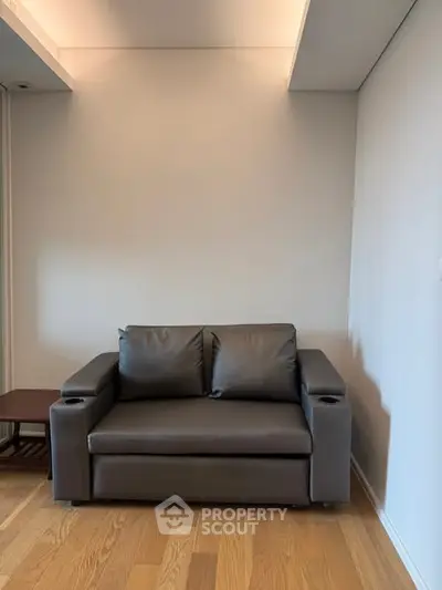 Modern living room with sleek gray sofa and wooden flooring, perfect for minimalist design enthusiasts.
