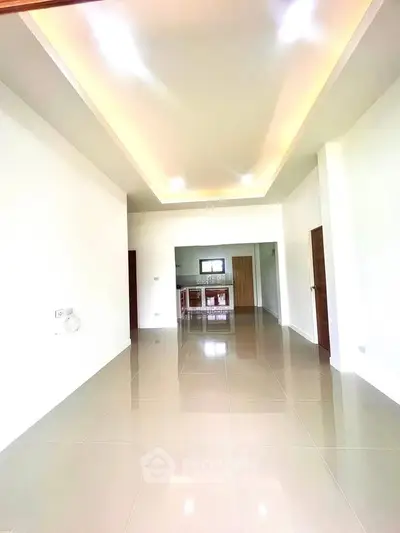 Spacious open-plan living area with modern kitchen in bright, minimalist design