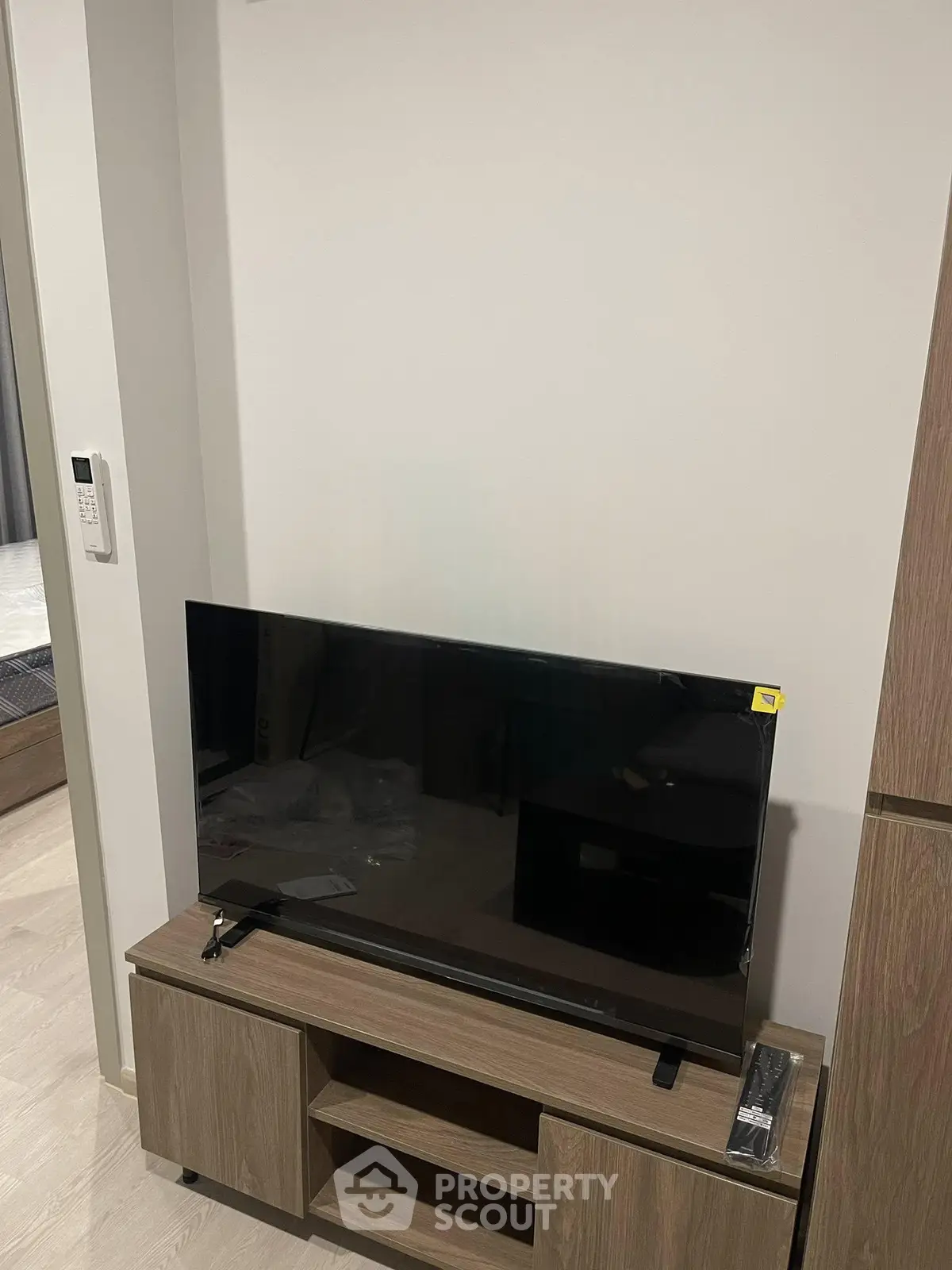 Modern living room with sleek TV stand and flat-screen TV, showcasing minimalist interior design.