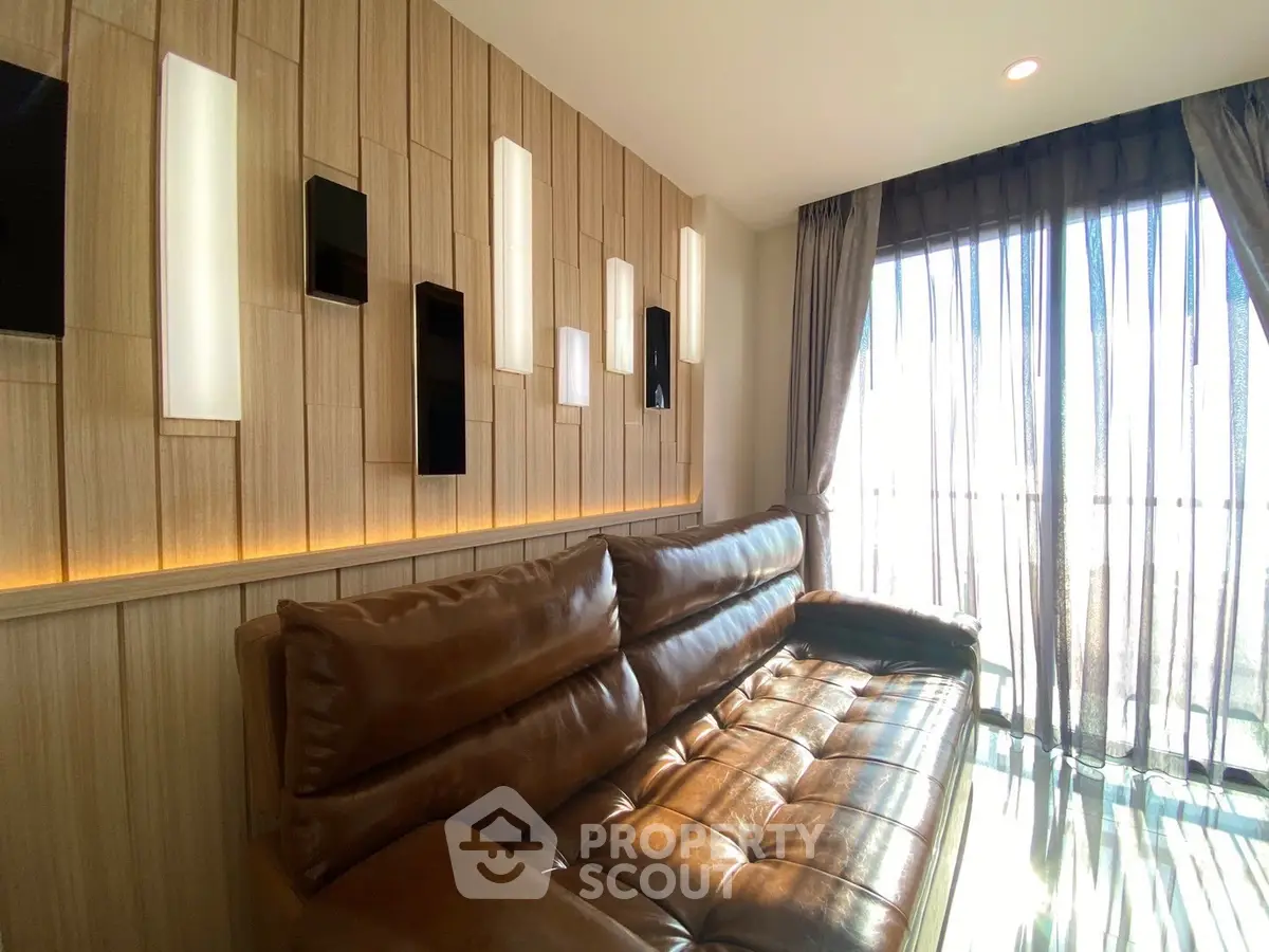 Luxurious living room with modern leather sofa and stylish wall lighting, featuring floor-to-ceiling windows for natural light.