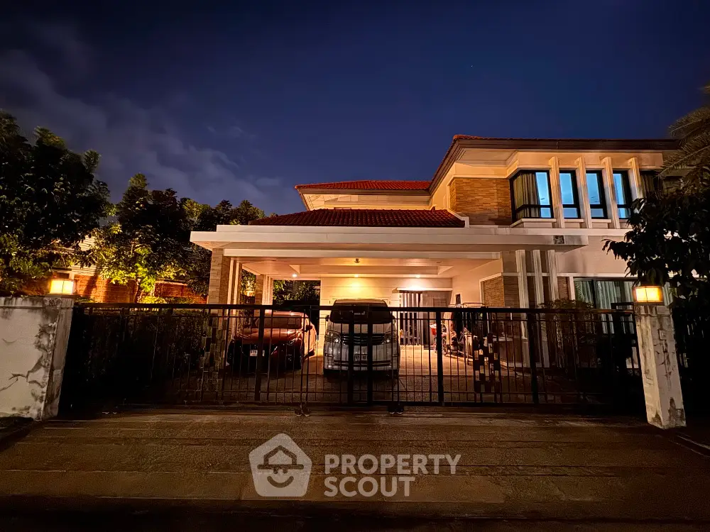 Luxurious modern house exterior with spacious driveway and elegant lighting at night