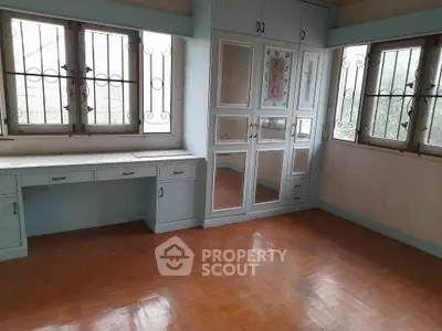 Spacious bedroom with built-in wardrobe and large windows for natural light.