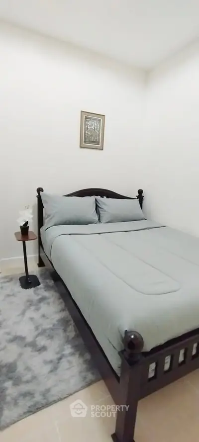 Cozy bedroom with elegant wooden bed and soft gray bedding