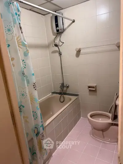 Cozy bathroom with bathtub and floral shower curtain in a tiled setting.