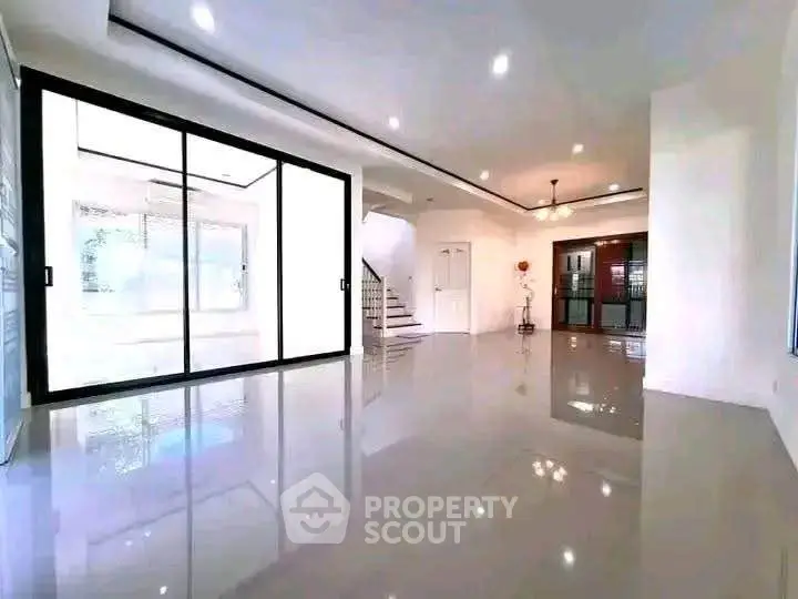 Spacious modern living room with glossy floors and large sliding glass doors.