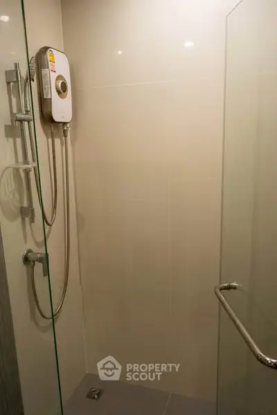 Modern bathroom with glass shower enclosure and wall-mounted shower unit.