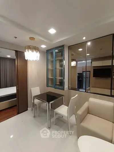 Modern living room with elegant chandelier and dining area in a stylish apartment