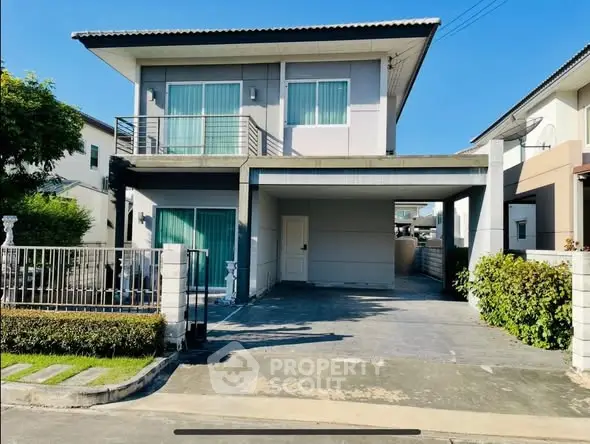 Modern two-story house with driveway and balcony in a suburban neighborhood.