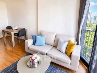 Modern living room with city view, stylish decor, and cozy seating area.
