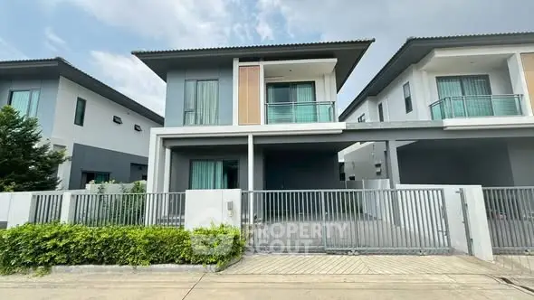 Modern two-story house with sleek design and gated driveway