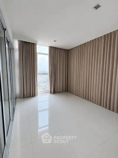 Spacious empty room with large windows and elegant curtains, perfect for customization.