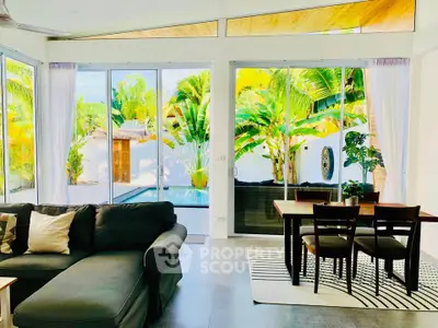 Modern living room with large windows overlooking lush garden and pool, featuring stylish furniture and open layout.
