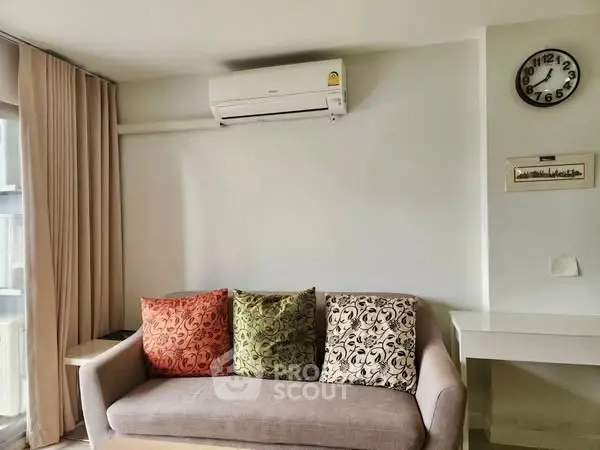 Cozy living room with modern sofa and air conditioning, perfect for relaxation.