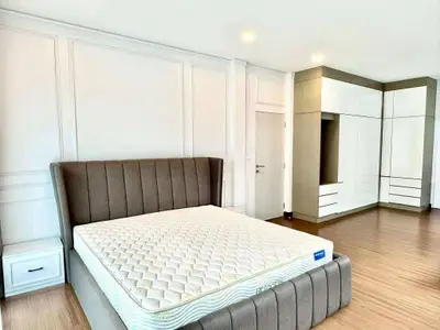 Spacious modern bedroom with elegant furnishings and ample storage space.