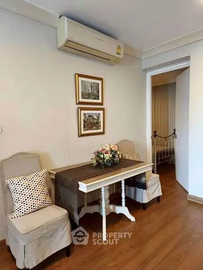 Charming small living area with elegant decor and air conditioning, perfect for cozy gatherings.