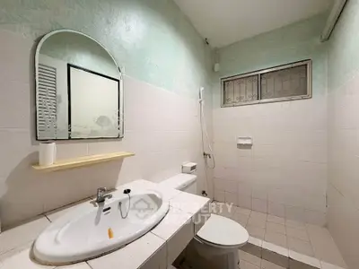 Spacious bathroom with modern fixtures and a large mirror, perfect for relaxation and comfort.
