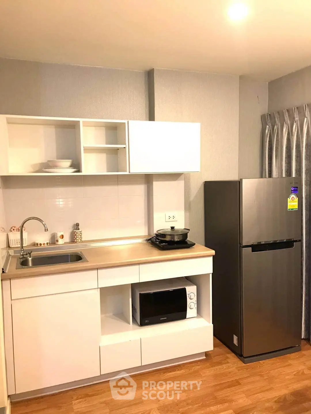 Modern kitchen with sleek appliances and stylish cabinetry in a cozy apartment setting.