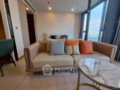 Modern living room with stylish sofa and city view from large windows