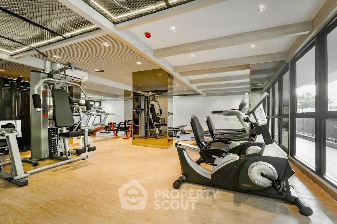 Modern gym with state-of-the-art equipment and large windows for natural light.