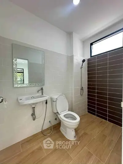 Modern bathroom with sleek design, featuring a shower, toilet, and stylish tiles.