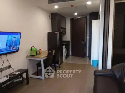 Modern apartment interior with open living area, kitchen, and dining space featuring sleek furniture and appliances.