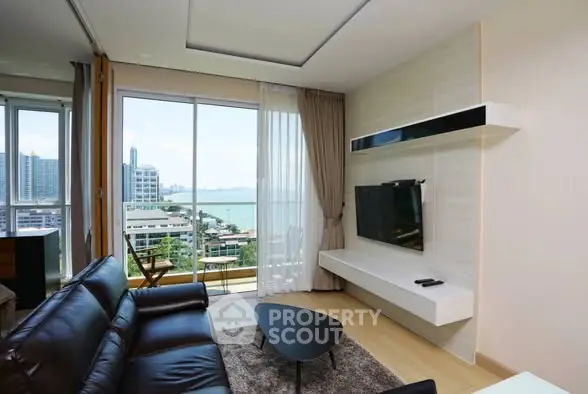 Modern living room with stunning city and sea view, featuring sleek furniture and large windows.