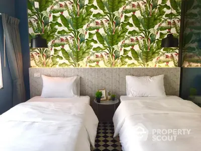 Chic bedroom with twin beds and tropical wallpaper, perfect for modern living.