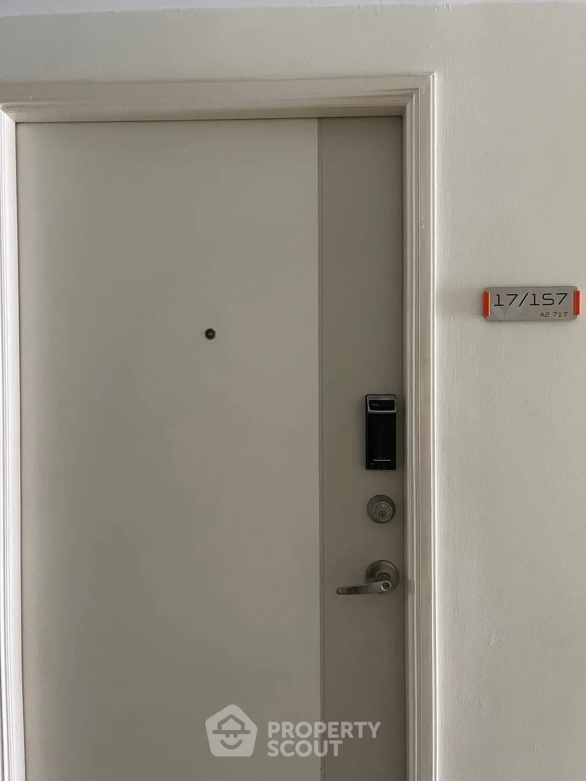 Modern apartment entrance with secure digital lock and unit number displayed.